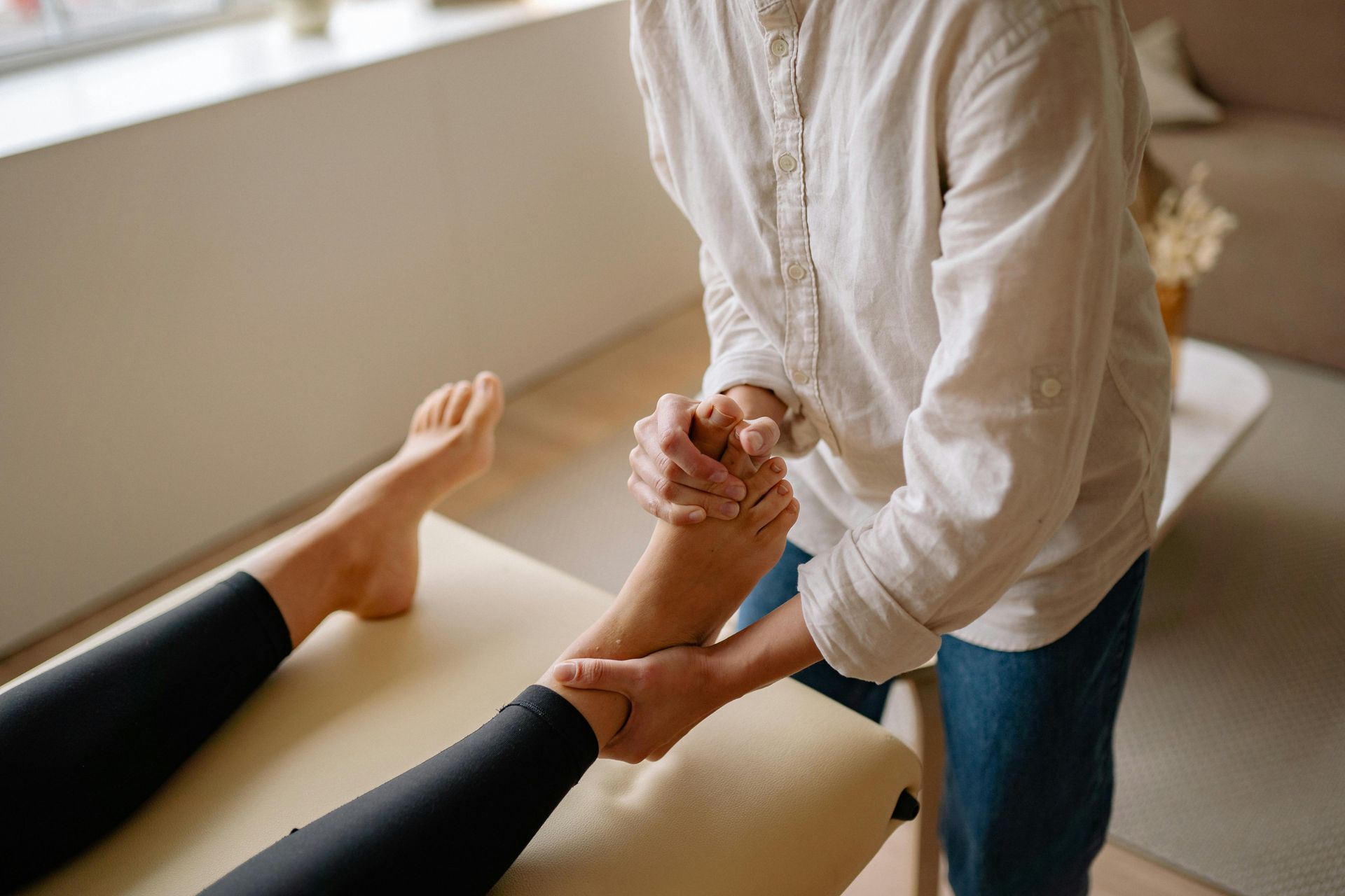 A person is giving a foot massage to another person.
